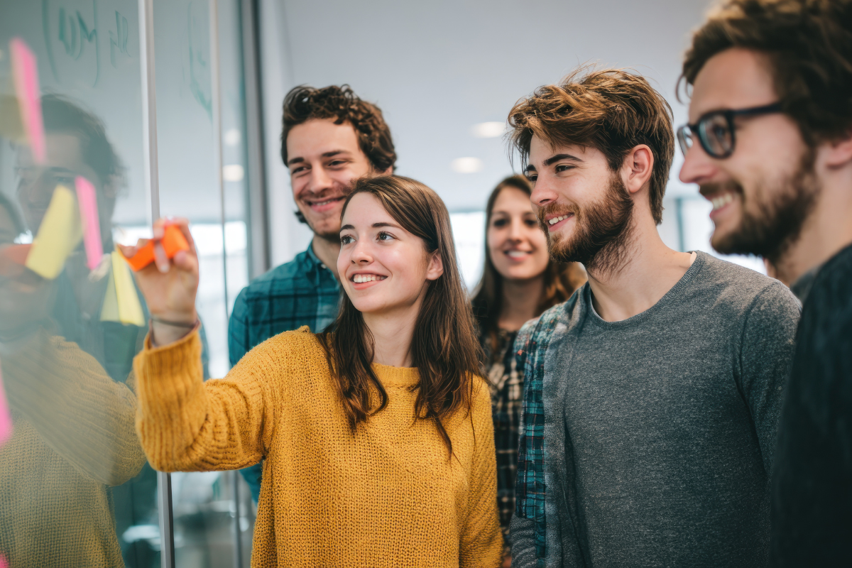 group of young professionals working on a dry erase board