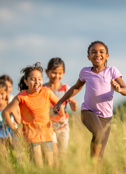 kids running through field 