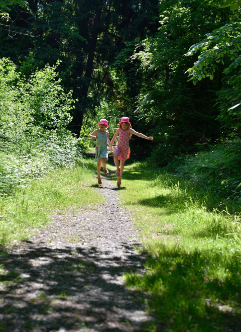 kids running on greenery filled path 